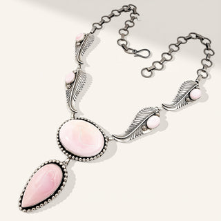 Necklace with pink stones and silver feathers on a white background