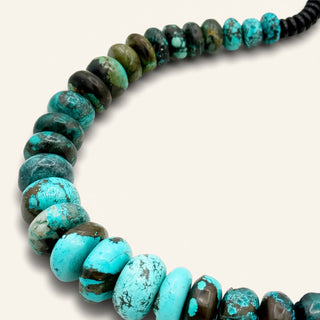 Necklace with turquoise and black beads on a white background