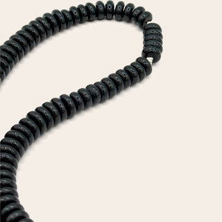 Black coiled hose on a white background