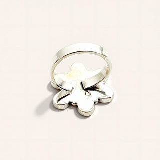 Silver ring with a butterfly design on a light beige background