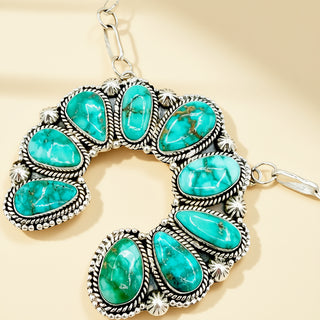 Turquoise stone bracelet with silver accents on a beige background