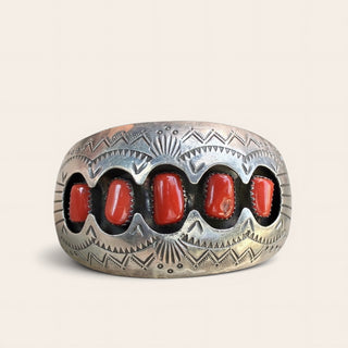 Silver cuff with red stones on a beige background