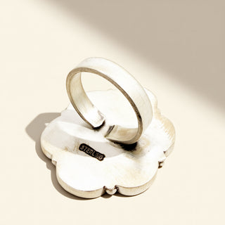 Silver ring with a textured surface on a light beige background