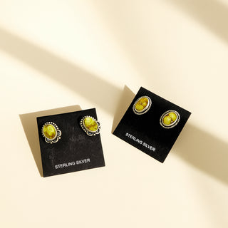 Pair of yellow gemstone earrings on black card with 'Sterling Silver' text, on a beige background