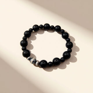 Black beaded bracelet on a beige background