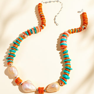 Necklace with orange and turquoise beads on a beige background