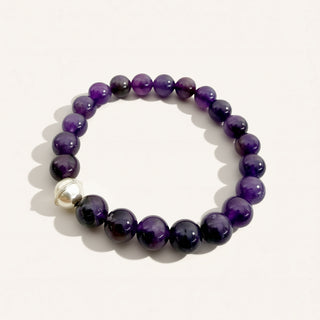 Purple beaded bracelet with a silver clasp on a white background