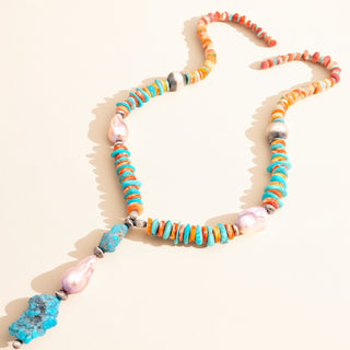 Necklace with mutli-color stones and pearls on a beige background