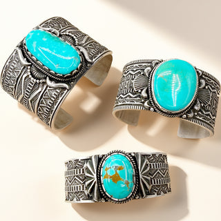 Three silver cuff bracelets with turquoise stones on a beige background