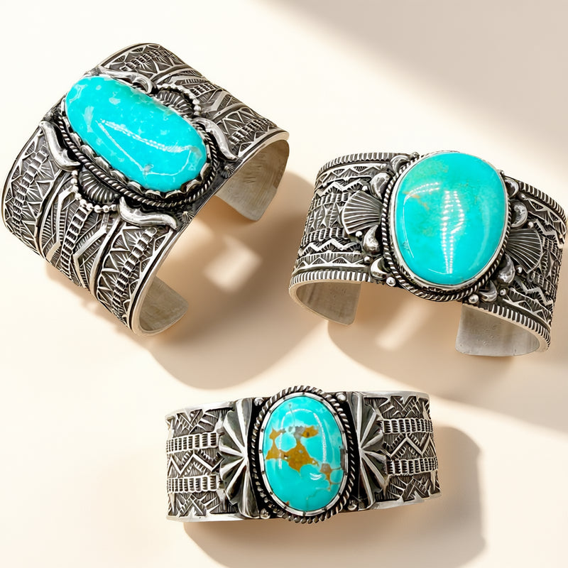 Three silver cuff bracelets with turquoise stones on a beige background
