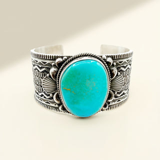 Silver bracelet with a turquoise stone on a light background