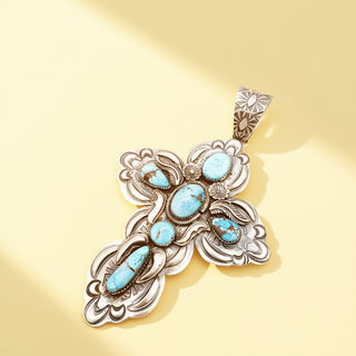 Cross pendant with turquoise stones on a beige background