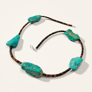 brown necklace with 5 chunky turquoise stones on a beige background