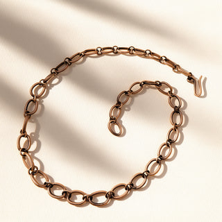 Rose gold chain necklace on a beige background