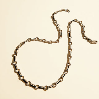 Gold chain necklace on a beige background