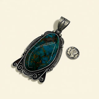 Silver pendant with a blue stone on a beige background