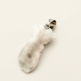 silver pendant on a beige background