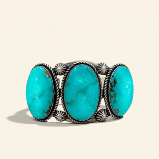 Turquoise stone cuff with silver band on a beige background