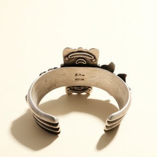 Silver bracelet with black accents on a beige background