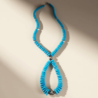Turquoise necklace with silver beads on a beige background