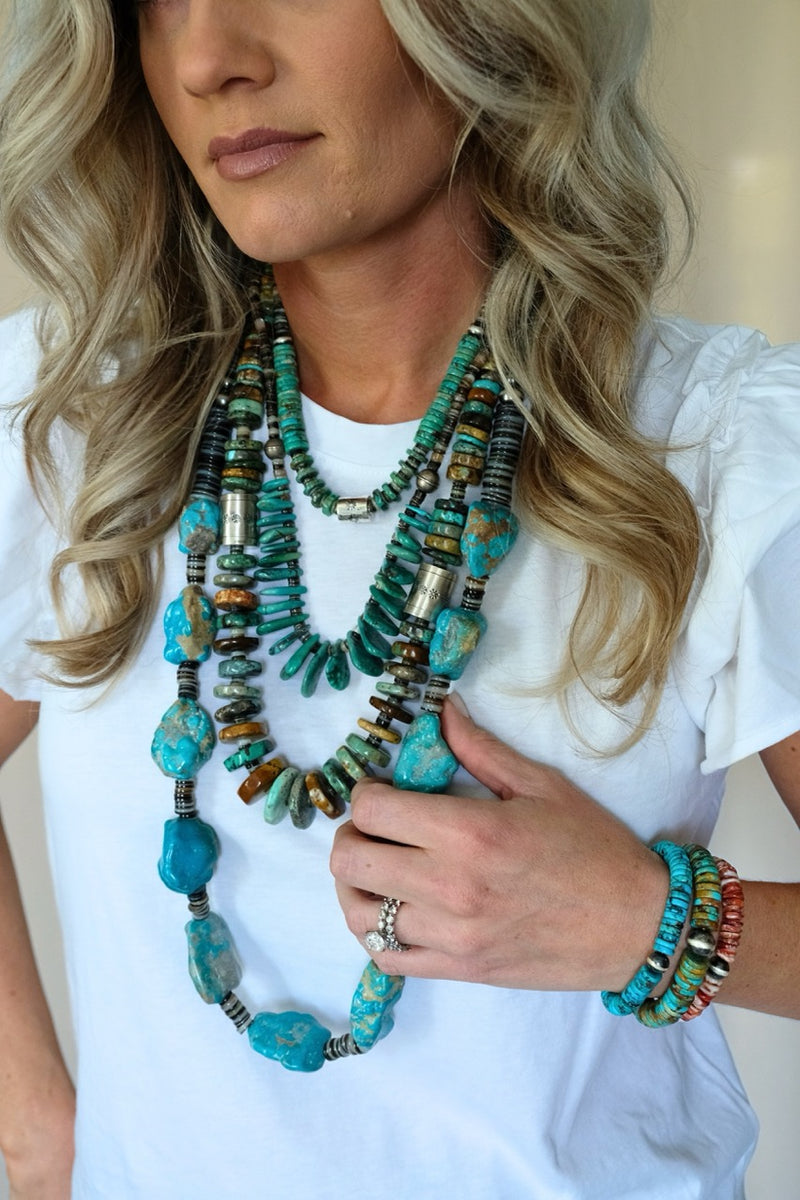 Woman wearing a colorful beaded necklace and bracelets on a white background