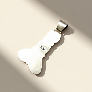 Silver stone pendant with silver hook on a beige background