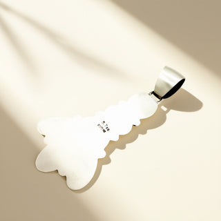 Silver pendant with stamp on a beige background