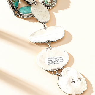 Navajo handmade silver and turquoise jewelry set on a beige background