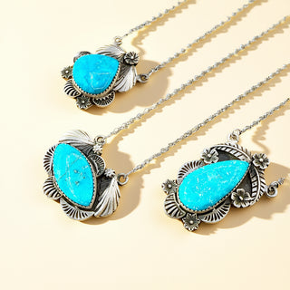 Turquoise stone necklaces with silver settings on a beige background