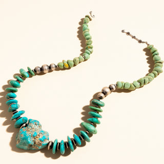 Necklace with turquoise stones and a large turquoise stone pendant on a white background