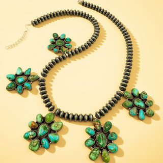 Black pearl necklace with turquoise stone pendants on a beige background