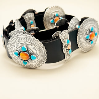 Black belt with silver concho-style buckles featuring colorful stones on a beige background