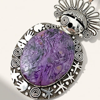 silver maiden pendant with purple stone on a beige background