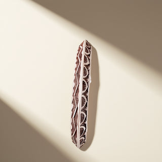 Silver cuff with designs on a beige background