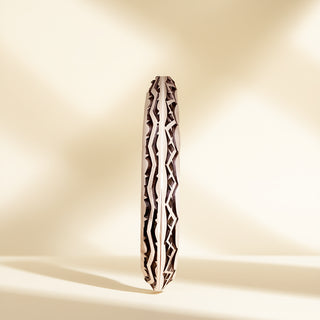 Silver cuff with designs on a beige background