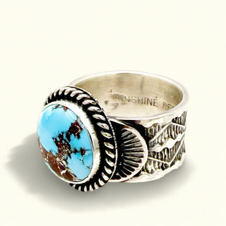 Silver ring with a blue stone on a beige background
