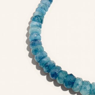 blue beaded jewelry on a beige background