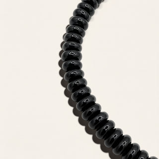 black beaded jewelry on a beige background