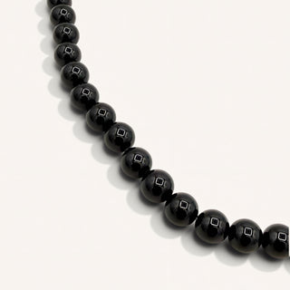 black beaded jewelry on a beige background