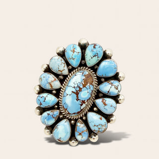 Turquoise stone ring with silver accents on a beige background