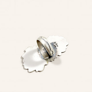 A sterling silver ring on a beige background
