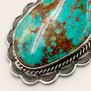 Turquoise stone with silver frame on a white background