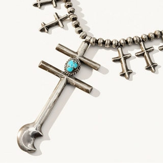 silver jewelry with turquoise stone on an off white background