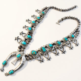Silver necklace with turquoise stones on a white background