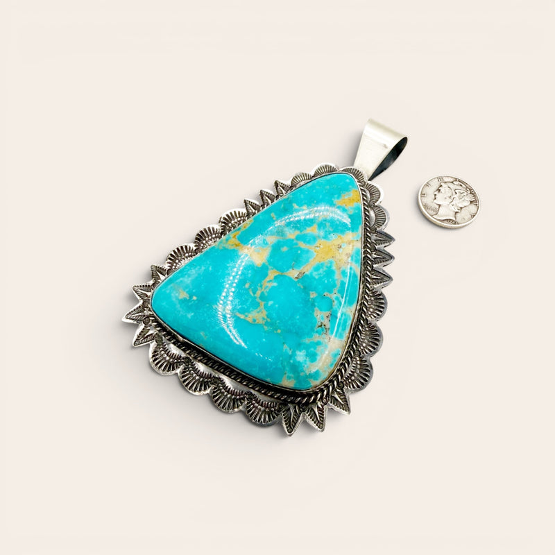 Turquoise stone pendant with silver frame on a white background