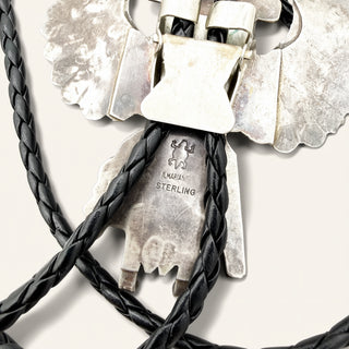 Close-up of a sterling silver and black braided cord necklace with a decorative silver clasp and engraved 'STERLING' text on the metal.