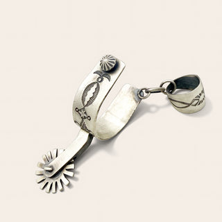 Silver spurs on a light beige background