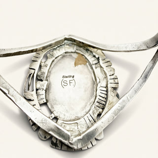 silver jewelry with engraving on a beige background