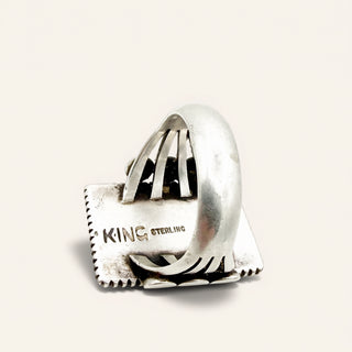 Silver ring with 'King' branding on a light gray background