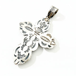 The back of a silver cross pendant stamped and showing the name Richard Yazza